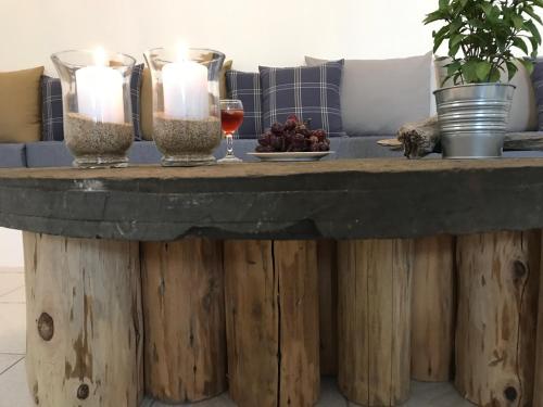 un tavolo con due candele e un bicchiere di vino di Panai's Garden a Livadi Astypalaias