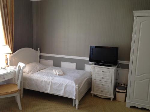 a bedroom with a bed and a tv on a dresser at Hotel Saint Petersburg in Karlovy Vary