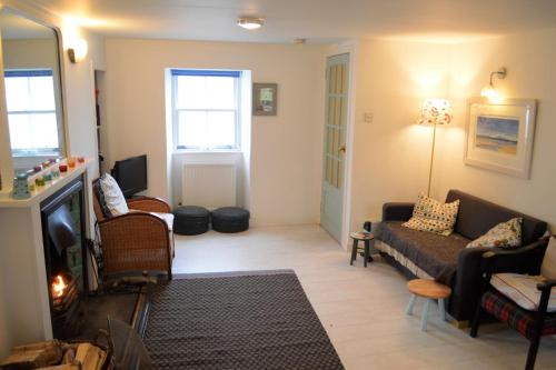 a living room with a couch and a tv at Newton Cottage North in Inveraray