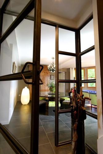 a room with a large glass door with a living room at Comme une parenthèse au coeur des hortillonnages in Amiens