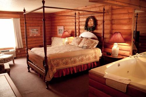 Schlafzimmer mit einem Bett und einer Badewanne in der Unterkunft Baymont by Wyndham Mequon Milwaukee Area in Mequon