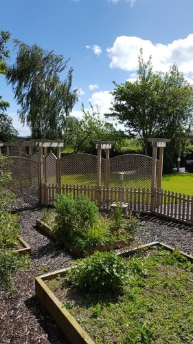 a garden with a wooden fence and some plants at Ruth's Rest Country Retreat with private Hot Tub in Shrewsbury