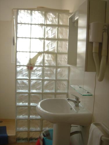 a bathroom with a white sink and a window at Aparthotel Ponta Preta in Santa Maria