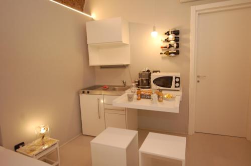 een kleine keuken met een wastafel en een magnetron bij La Rosa Scarlatta in Bergamo