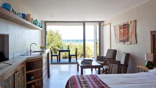 
a room with a bed, table, chairs and a window at Oceano Patagonia Wild Coast Residence in Puerto Pirámides
