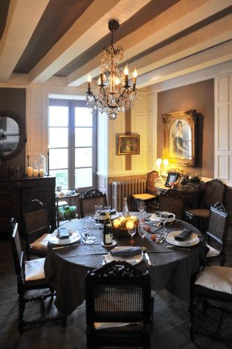 a dining room with a table and a chandelier at Saint Victor La Grand' Maison in Ingrandes