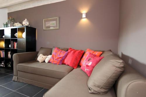 a living room with a brown couch with colorful pillows at Comme une parenthèse au coeur des hortillonnages in Amiens
