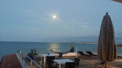 a view of the ocean from a balcony with tables and umbrellas at B&B alla Canale in Vasto