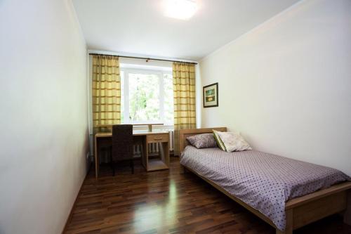 1 dormitorio con cama, escritorio y ventana en Katariina Apartment en Võru