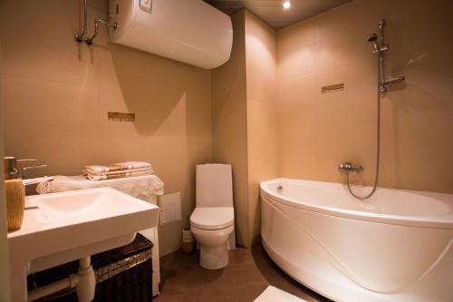 ein Badezimmer mit einer Badewanne, einem WC und einem Waschbecken in der Unterkunft Katariina Apartment in Võru