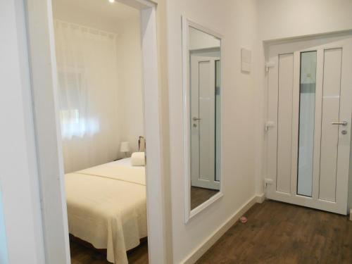 Habitación blanca con cama y espejo en Z&D Apartment, en Pula