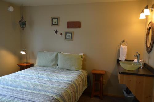 a bedroom with a bed and a sink next to a bed at Bay Avenue Inn in Homer