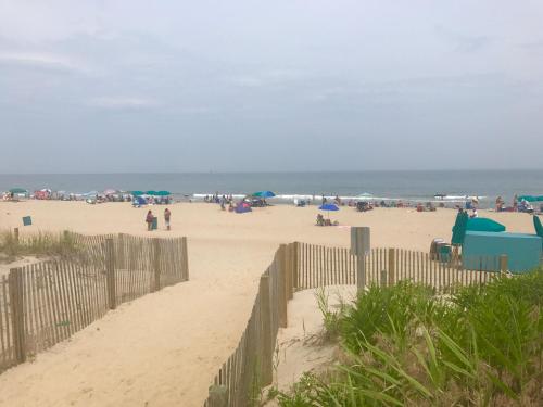 un groupe de personnes sur une plage de sable dans l'établissement Tides Inn, à Ocean City