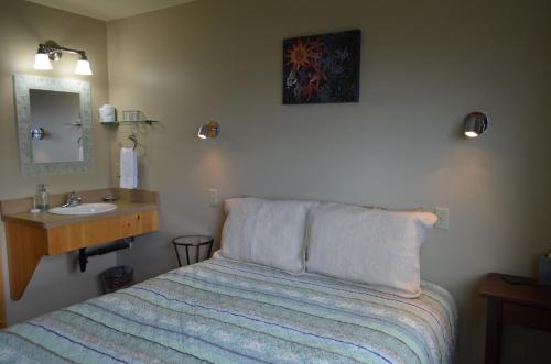 a bedroom with a bed and a sink in it at Bay Avenue Inn in Homer