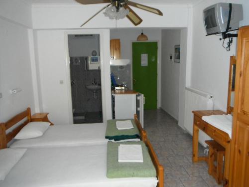 a room with two beds and a bathroom with a sink at Dimitris Apartments in Vasiliki