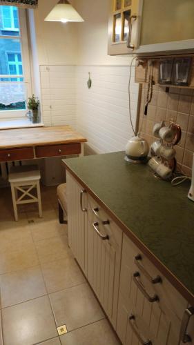 a kitchen with a green counter top and a table at W kamienicy in Gdańsk