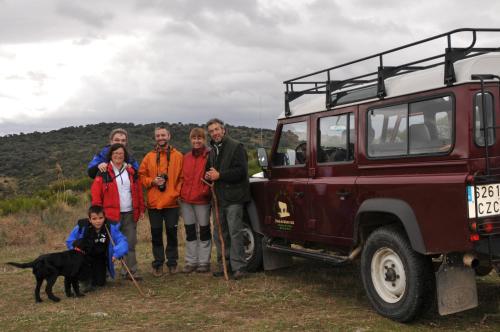 a group of people standing next to a red jeep at Posada Real La Mula de los Arribes in Villardiegua de la Ribera
