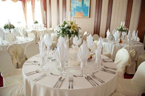 a dining room with white tables and white chairs at Hotel Wellness & Spa Nowy Dwór in Rzeszów