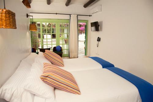 a bed with a white blanket and a blue comforter at Hotelito La Era B&B in Yaiza