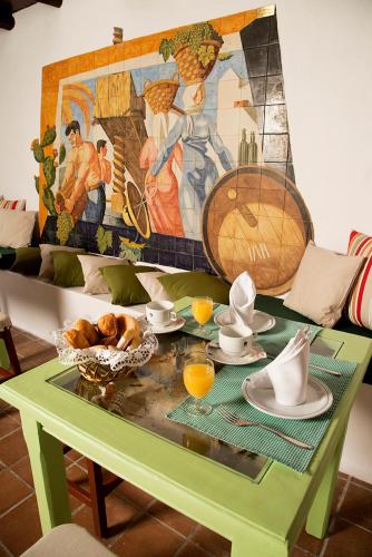 a green table with food on it with a mural at Hotelito La Era B&B in Yaiza