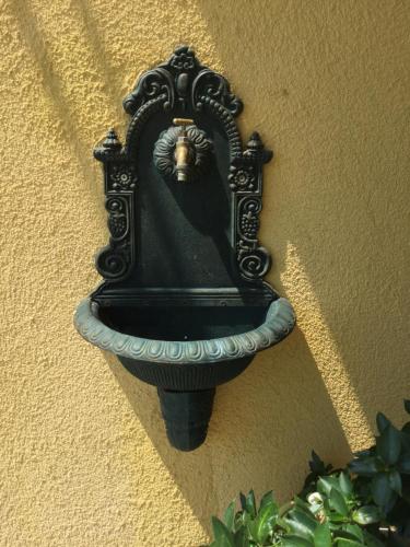 a black bird bath on the side of a wall at Appartements Panorama Schlössl in Velden am Wörthersee
