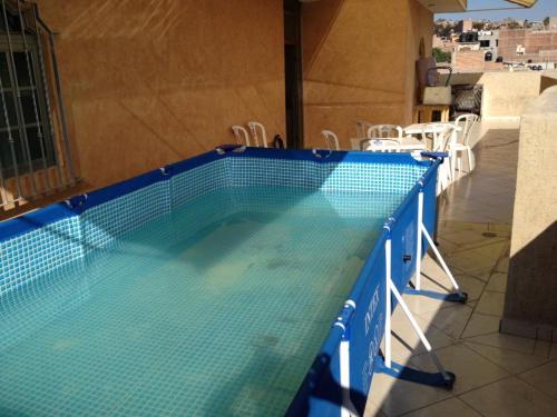 a blue swimming pool with chairs and tables at Hotel Hacienda Salvador in San Juan de los Lagos