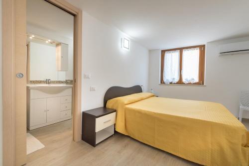 a bedroom with a yellow bed and a mirror at Residence Blue Pearl in Marina di Camerota