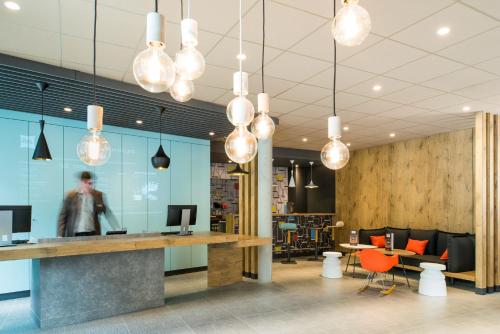 an office lobby with a reception desk and lights at ibis Saint Germain en Laye Centre in Saint-Germain-en-Laye