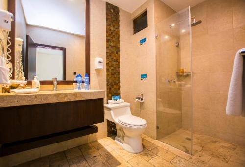 y baño con aseo, lavabo y ducha. en Hotel Isla Sol by Solymar, en Puerto Ayora