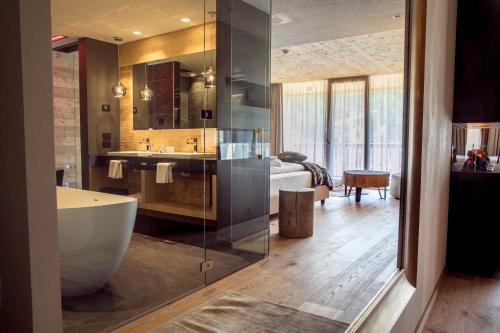 a bathroom with a large tub and a sink at Hotel Gran Paradiso in San Cassiano