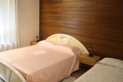 a hospital room with a bed and a wooden wall at Albergo Stazione in Bodio