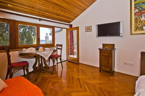 a living room with a table and a tv at Castle Štambuk in Hvar