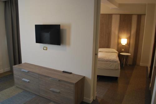 a room with a dresser and a tv on a wall at Hotel Europa in Garda