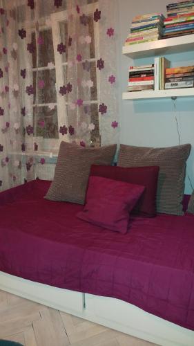 a bed with a purple comforter in a room at W kamienicy in Gdańsk