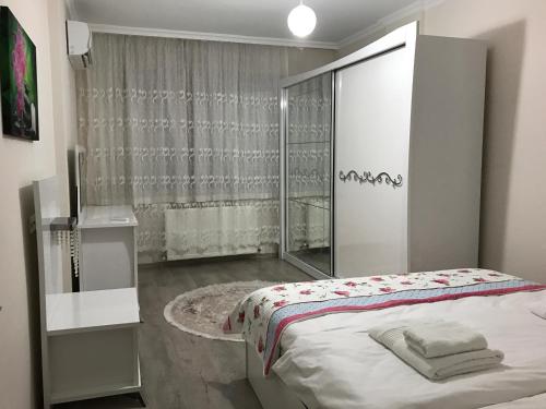 トラブゾンにあるSakura Apartments Trabzonの白いベッドルーム(ベッド1台、鏡付)