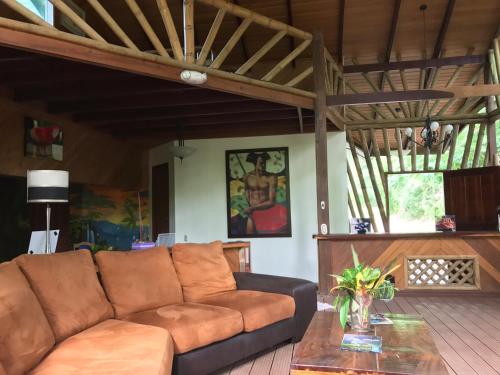 a living room with a brown couch and a table at Casa Manglar Villa in Puerto Jiménez