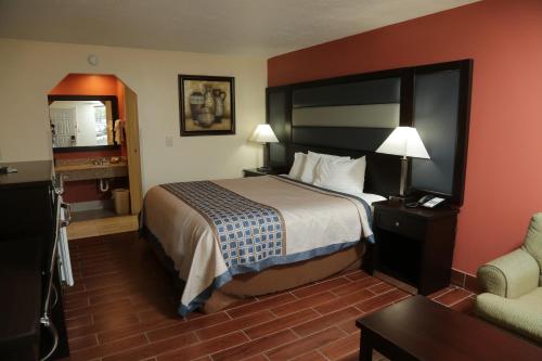 a hotel room with a bed and a chair at Budget Inn - Washington in Washington