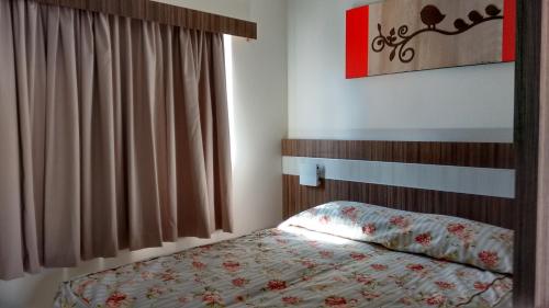 a small bedroom with a bed and a window at Lacqua Diroma Caldas Novas in Caldas Novas