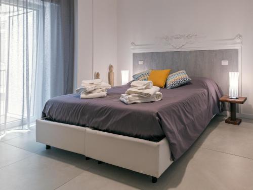 a bedroom with a large bed with towels on it at Le Caruse in Lecce