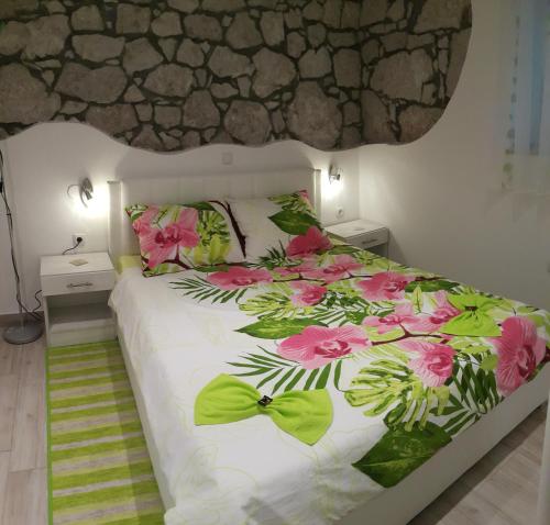 Apartments 4M في كوسترينا: غرفة نوم مع سرير مع زهور وردية عليه