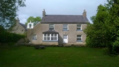 an old house with a grass yard in front of it at Creevy Lodge in Castlederg