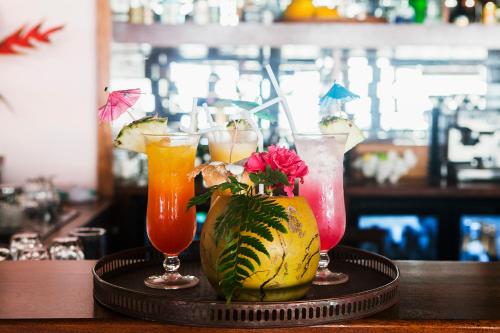 a tray with three cocktails on a bar with a pineapple at Aore Island Resort in Luganville