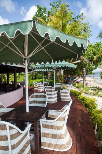 a group of tables and chairs with an umbrella at Aore Island Resort in Luganville