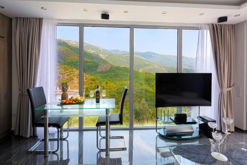 a living room with a table and a large window at Montelux Apartments in Budva