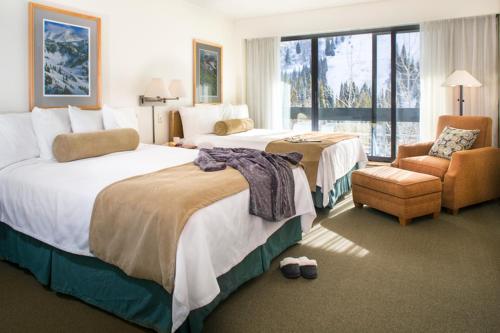 a hotel room with two beds and a chair at Inn at Snowbird in The Cliff Lodge