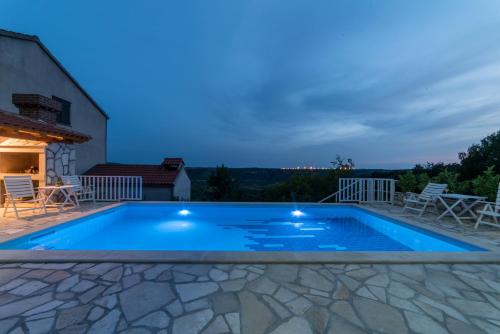 a swimming pool in the backyard of a house at Olive Garden Apartments in Čilipi