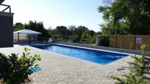 a swimming pool in a backyard with a fence at House Barbara in Banjole