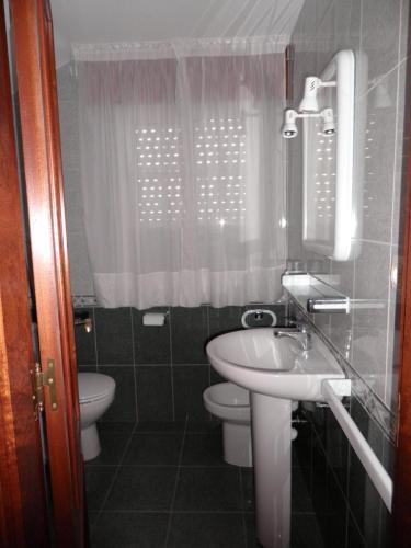 uma pequena casa de banho com lavatório e WC em Novas Foxos (Ático) em A Lanzada
