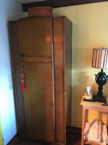 a large wooden cabinet in a room with a lamp at Klutina Kate's B&B in Copper Center