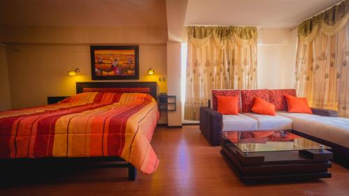 - une chambre avec un lit et un canapé dans l'établissement Hotel Koricancha, à Sicuani